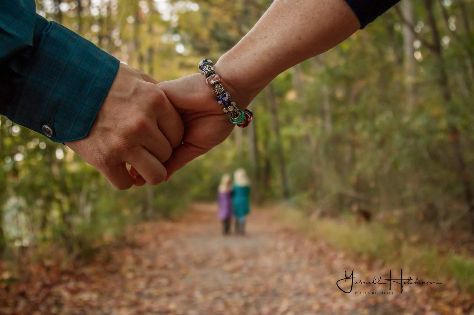 End of article: Couple holding hands with kids in distance