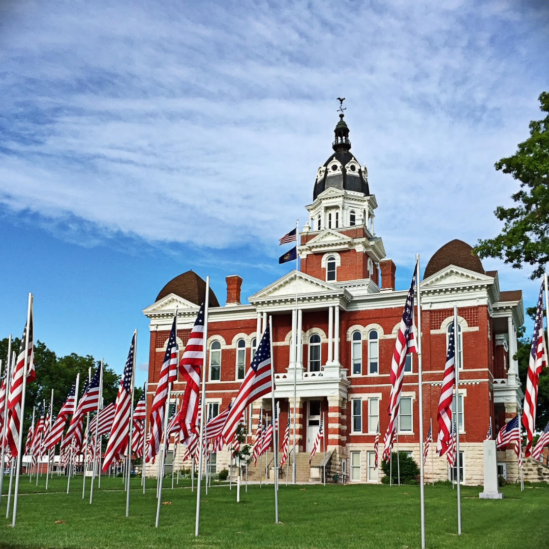 stately building surrounded by American Flags