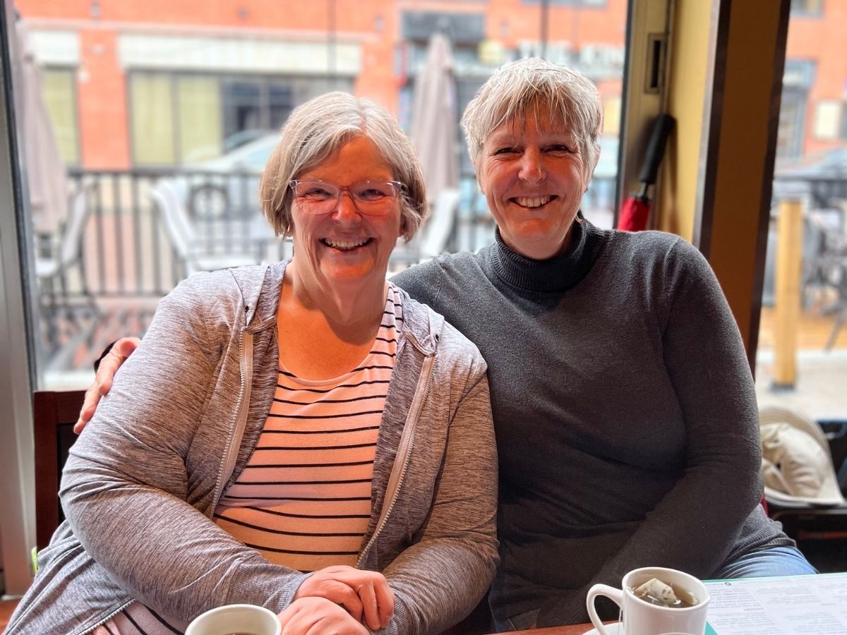 two women smile for photo in restaurant