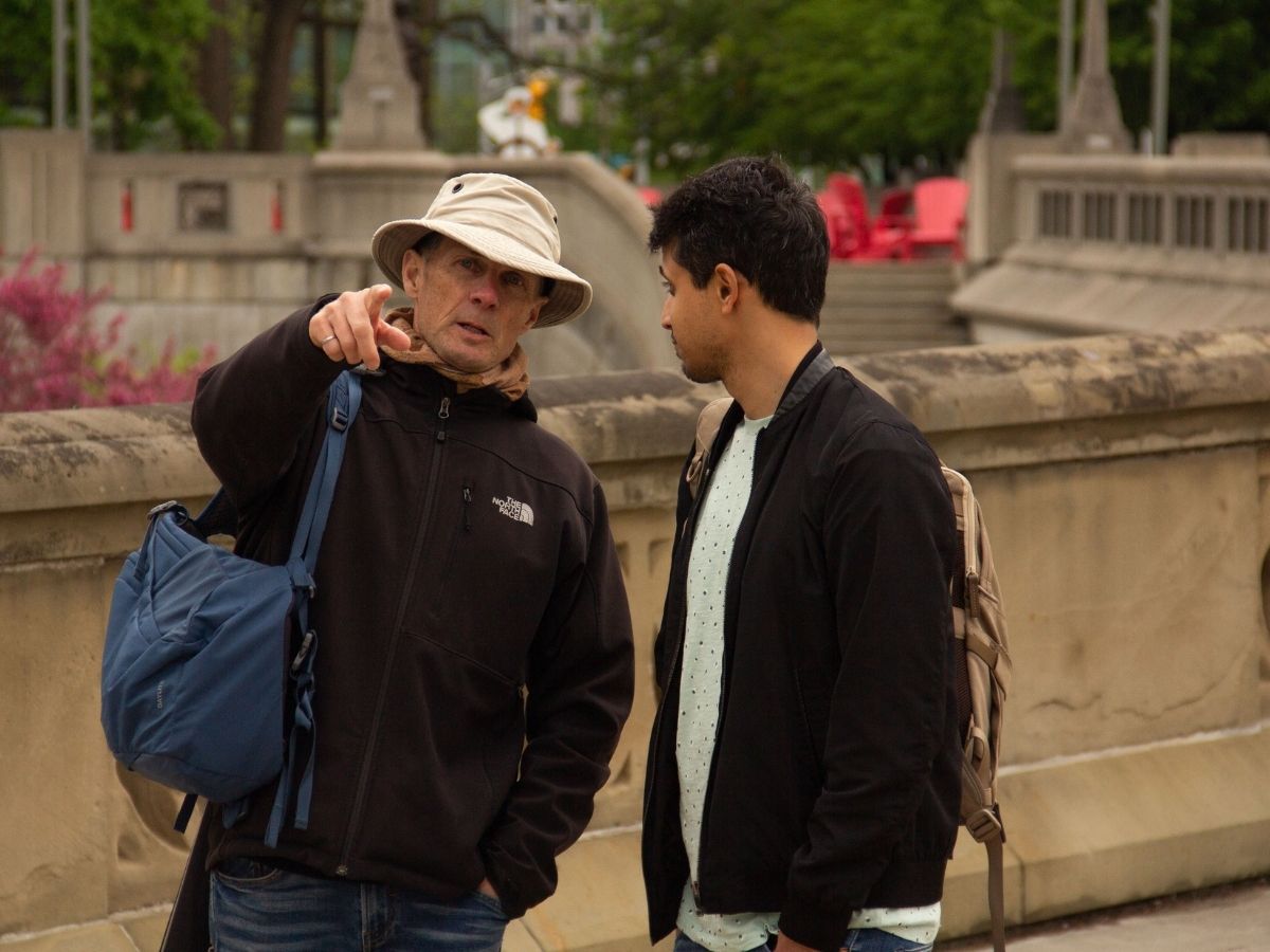 Two men talking, wearing backpacks