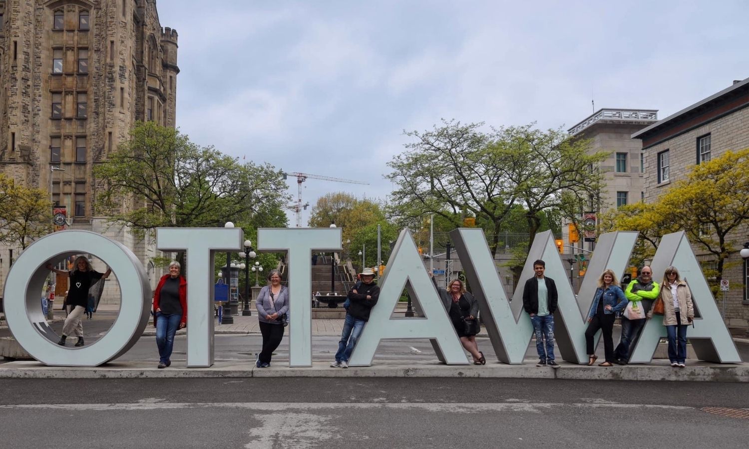 Group of people pose with Ottawa sign in Byward Market