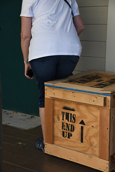 Woman about to sit on wooden crate