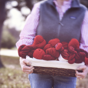 Holding a basket of red yarn